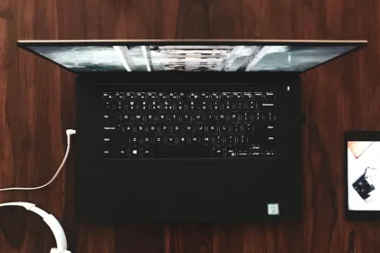 black and gray laptop computer turned on on wooden surface