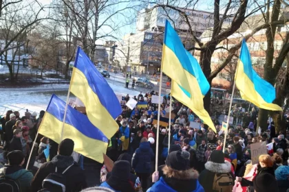 a group of people holding flags in a park