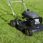 black and yellow push lawn mower on green grass during daytime
