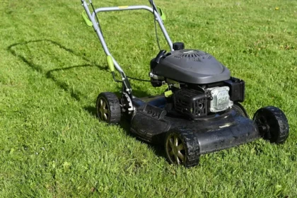 black and yellow push lawn mower on green grass during daytime