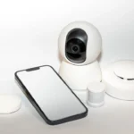 a smart phone sitting next to a security camera