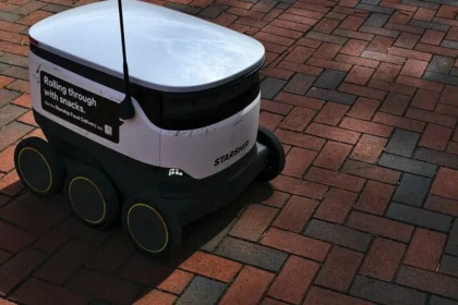a white and black robot sitting on top of a brick road