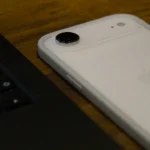 White iPhone with clear case next to laptop