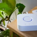Smart home hub and remote on a wooden table.
