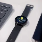 round black watch beside gray keyboard