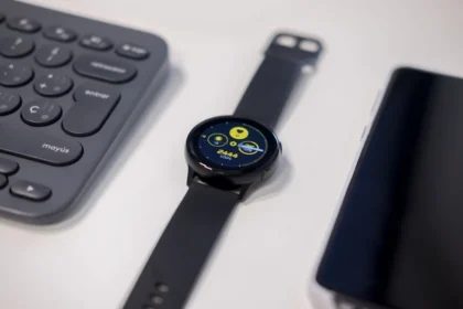 round black watch beside gray keyboard