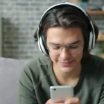 Young man wearing headphones and using smartphone