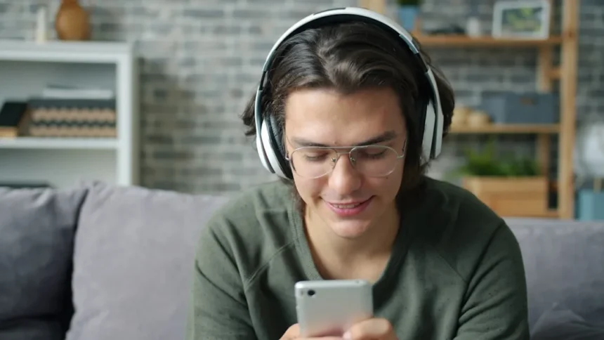 Young man wearing headphones and using smartphone