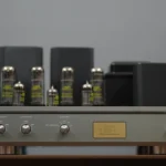 Vacuum tube amplifier with silver knobs and gold plate.