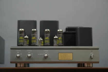 Vacuum tube amplifier with silver knobs and gold plate.